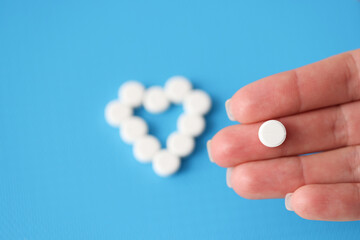 On the hands lies a white pill