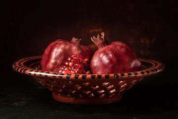 pomegranate and pomegranate grains on a clay plate