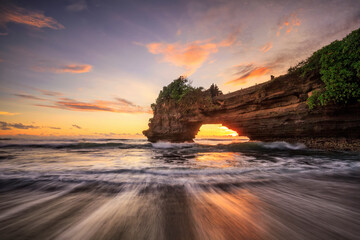 Sunset at Batu Bolong temple and Tanah Lot, Tabanan, Bali. beautiful color view in high tide from the bottom.