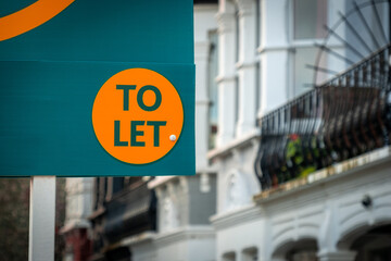 Estate agent To Let sign on sign board  on street of houses