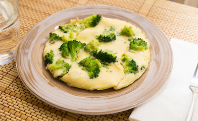wholesome breakfast. omelet with broccoli on brown plate