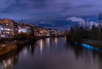Blue hour in Zürich, the largest city in Switzerland. Illuminated houses along the Limmat River and their reflections in the water