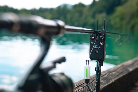 Electronic indicator, bite alarm, Spinning reel on a green blurred background. Concept: outdoor activities, fishing, outdoor recreation. Selective focus.