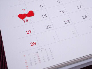 Red heart on the 14th day of the calendar page. Close up, with copy space for your text. Concepts Valentine's Day, anniversary, and wedding..