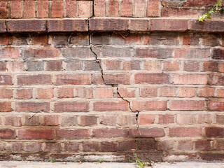 A cracked brick wall indicating sinking foundations requiring structural repair 