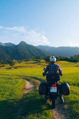 Man motorcyclist ride touring motorcycle. Alpine mountains on background. Biker lifestyle, world...