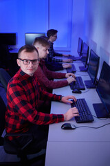 A group of young men work as programmers in the office. Esports players. A man wearing black-rimmed eyeglasses.