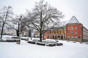 Fototapeta na wymiar Snow on Peace square, red building of city hall in winter morning, Zlin, Czech republic.