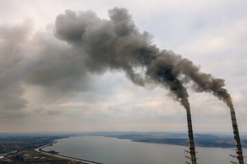 Naklejka na ściany i meble Aerial view of coal power plant high pipes with black smoke moving up polluting atmosphere.