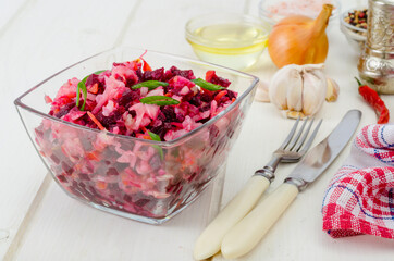 Vegetable salad with beets, spices, onions, garlic on wooden table