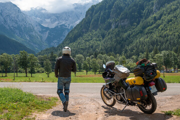 Fototapeta na wymiar Motorcyclist man and Adventure Motorbike with bags. Motorcycle trip. World Traveling, Lifestyle Travel vacations sport outdoor concept. Zgornje Jezersko Slovenia