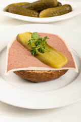 Liver pate cut on a bun with parsley and cucumber