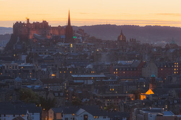 A view of Edinburgh Castle and Edinburgh's old town cityscape skyline at sunset or sunrise from Salisbury Crags.