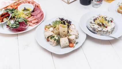Food tray with delicious salami, pieces of sliced ham, sausage. Cutting sausage and cured meat on a celebratory table.