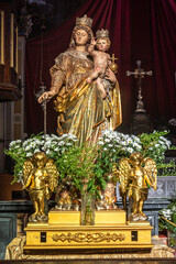 Fototapeta premium golden statue of the virgin Mary and baby Jesus inside a church