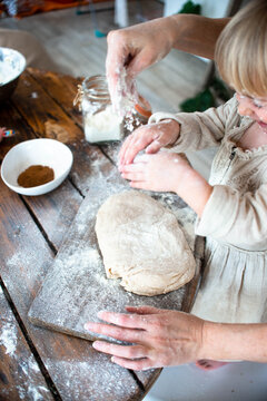 Cute little girl and her beautiful mom make dough in a bowl stay at home.