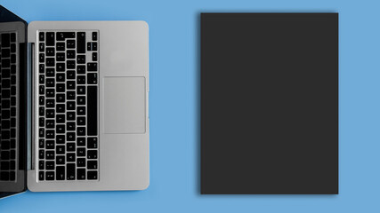 Fototapeta na wymiar Dark blank sheet. Laptop on a blue background.