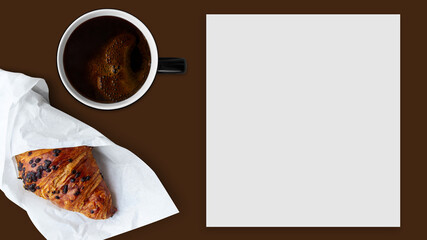 White blank sheet on brown background. Black cup with coffee, croissant.