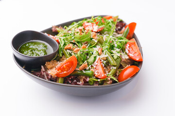 Photo of fresh vegan salad full of vitamins over white background.