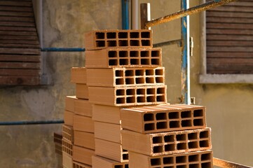 Hollow construction bricks stacked on a construction site on the scaffoldings (Pesaro, Italy, Europe)