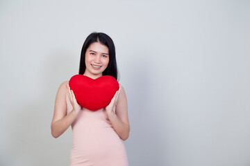 young Asian woman show heart shape pillow