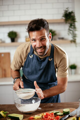 Happy man baking in the kitchen. Man making fresh pasta.