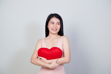 young Asian woman show heart shape pillow