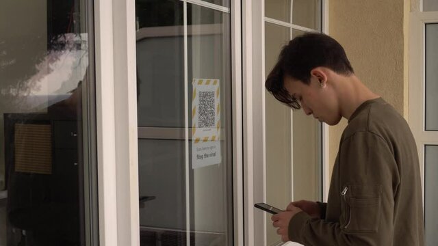 QR code on the doors at the entrance to the building. Scanning the QR code on the display using a smartphone. Internet URL, encrypted data, e-ticket, menu, contactless payment, citizen ID card, pass