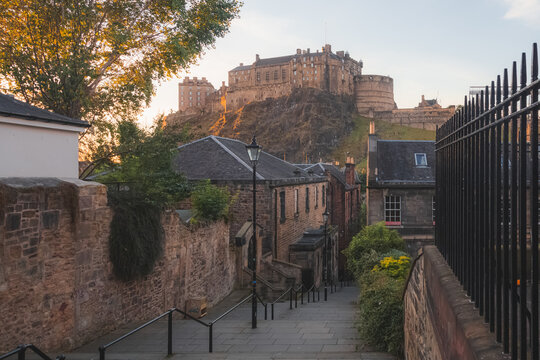 Classic view of Edinburgh Castle from the Vennel in the old town in summer with sunrise or sunset golden light.