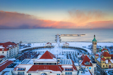 Beautiful sunset over the snowy beach and pier (Molo) in Sopot at winter. Poland - obrazy, fototapety, plakaty