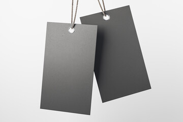 Blank hanging tags made from recycled beige and white eco-friendly kraft paper at plain light grey...