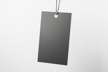 Blank beige eco label tag from recycled black paper on cotton twine at light empty background. Eco label tag concept. Mock up. 3D rendering