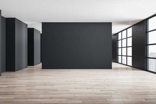 Concrete gallery interior with city view, daylight and blank gray wall.