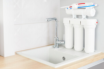 Concept purified water. Osmosis filter, clean water and tap on home kitchen.