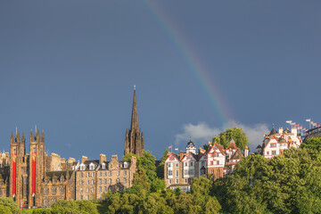 Obraz premium Rainbow over Ramsay Garden, Tollbooth Kirk and the old town skyline on a moody and colourful summer evening in Edinburgh, Scotland