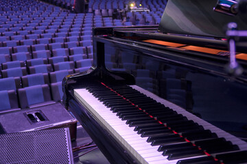 the grand piano stands on the stage of the concert hall
