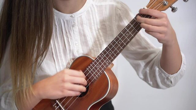 Woman with guitar on white background with copy space
