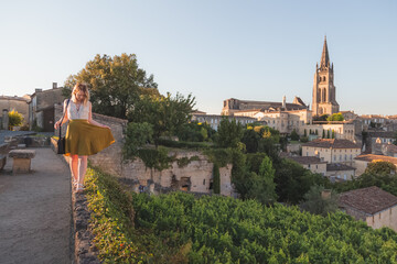 A young blonde tourist enjoying her holiday and vineyard view of the Monolithic Church and village...