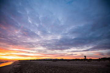 Atardecer desde la playa de Barcelona con cielo nublado
