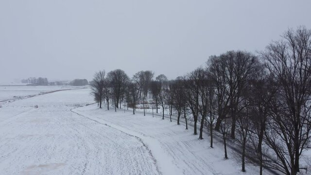Snowy winter view in a rural landscape in the delta of the river IJssel, Netherlands. Aerial drone point of view.