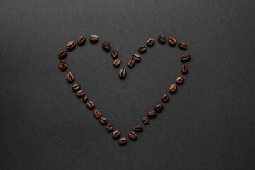 Heart shape made of toasted coffee beans on a dark background for coffee lovers