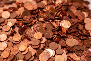 Many small euro coins lie on each other