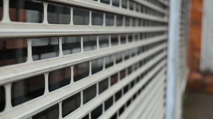 Metal security shutters protect a shop window