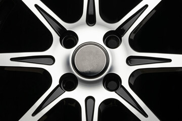 polished spokes of a car alloy wheel, close-up on a black background. front view