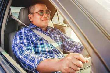 Asian men driving and wearing seat belts in smiling mood.