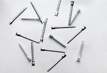 Collection of screw heads. Background of screws and dowels. Levitation of objects on a white...