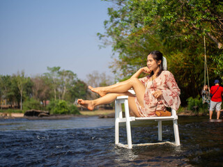 A woman sitting in a chair in the middle of the river
