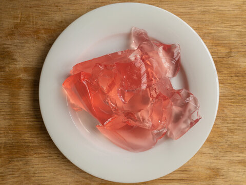 Top view on white plate full of strawberry jelly