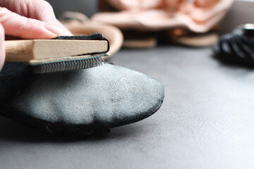 Wooden shoebrush next to ballroom dancing shoes. Use a brush to loosen the sole of the dance shoe...