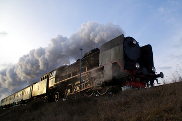 Fototapeta na wymiar Retro smoky steam locomotive on the former railway line